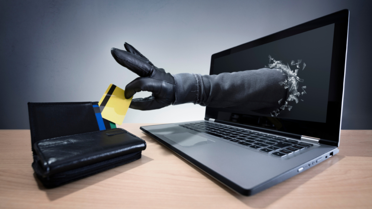 Stealing a credit card through a laptop concept for computer hacker, network security and electronic banking security